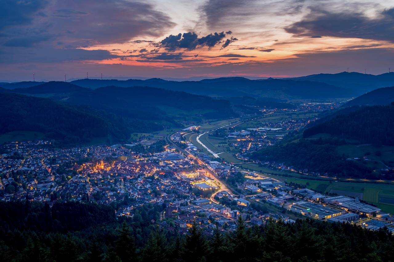 Scenic view of a city with streetlights and mountainous background at sunset, showcasing Battery Point